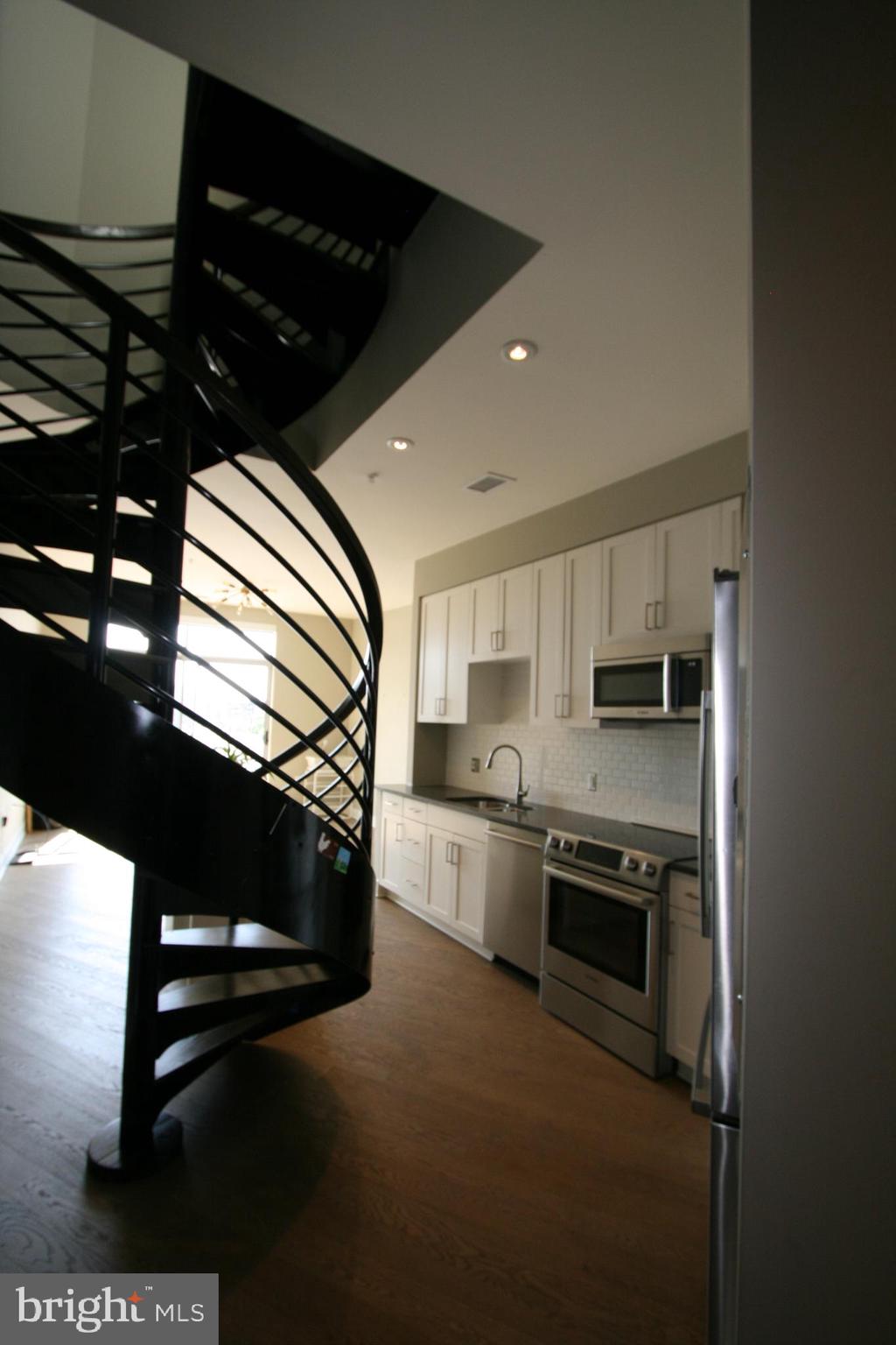 2550 17th Street Northwest, Unit 612 Washington, DC 20009 - Photo 26 of 55 a kitchen with stainless steel appliances kitchen island granite countertop a stove a sink and a microwave