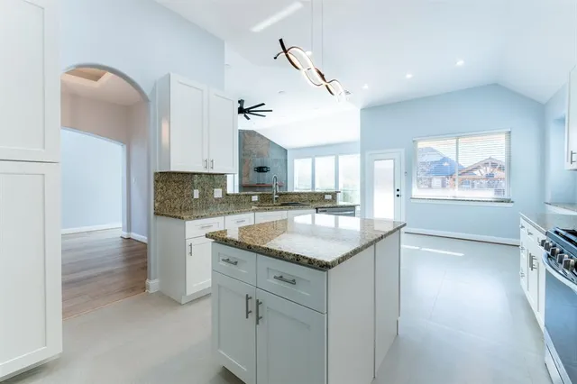 a kitchen with stainless steel appliances granite countertop a sink and a stove