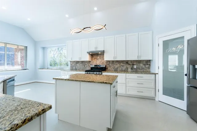 a kitchen with granite countertop a sink cabinets and window