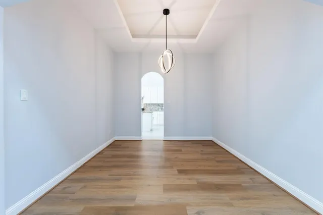 a view of empty room with wooden floor and window