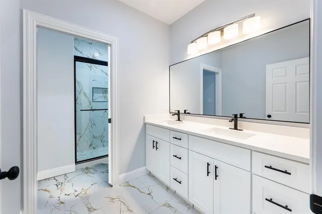 a bathroom with a double vanity sink and mirror