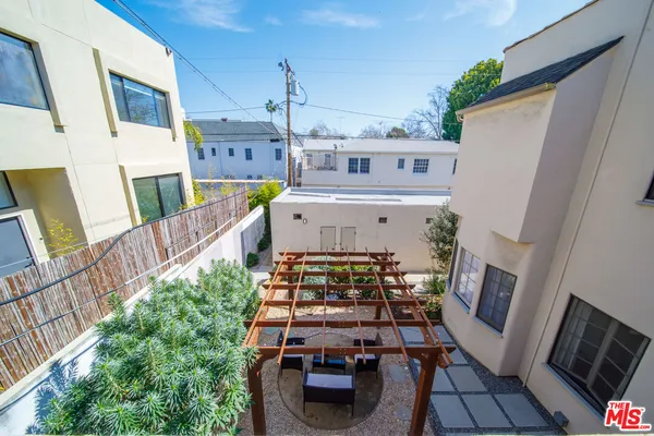 a view of a patio with table and chairs potted plants