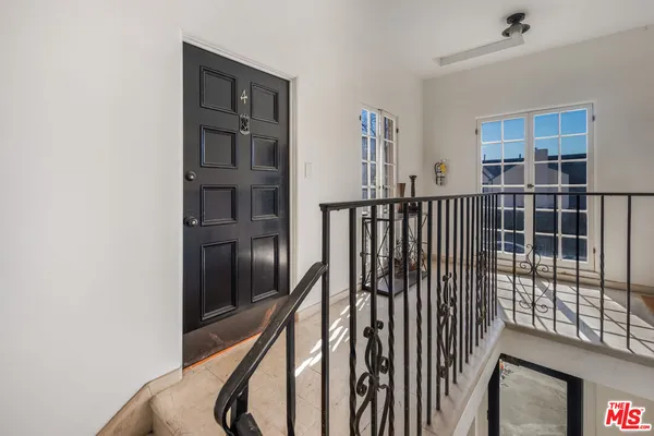 a view of staircase with lots of frames on wall and a window
