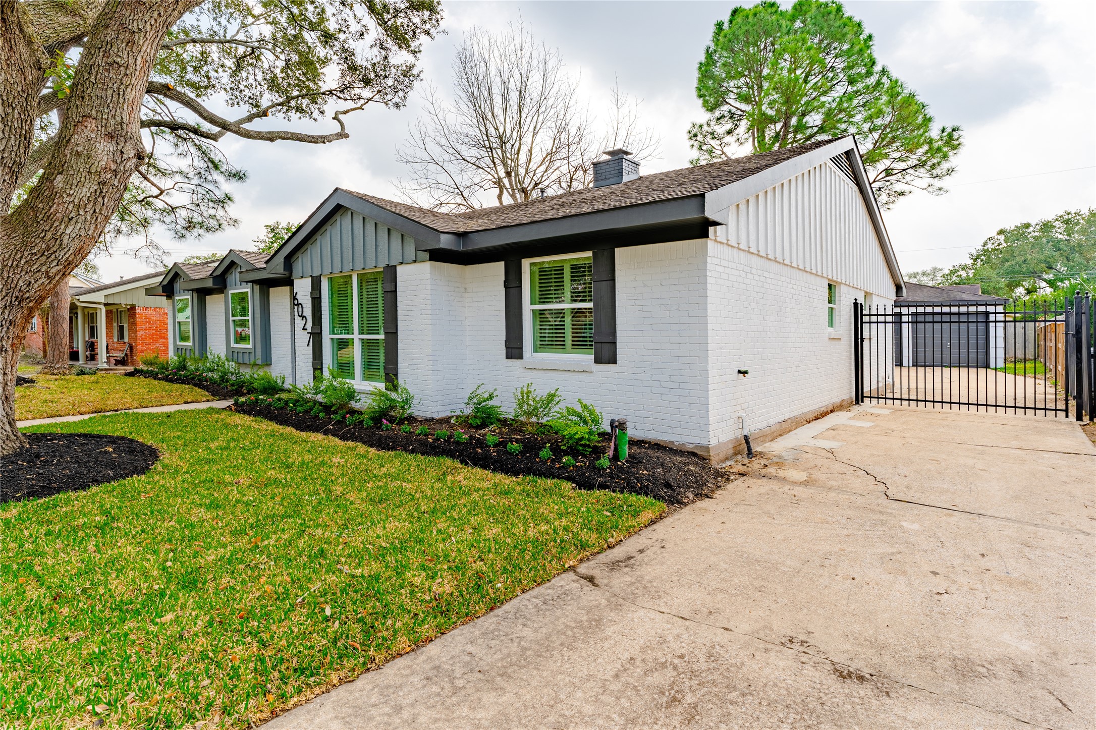 6027 Valkeith Drive Houston, TX 77096 - Photo 5 of 31 a view of a white house next to a yard with potted plants