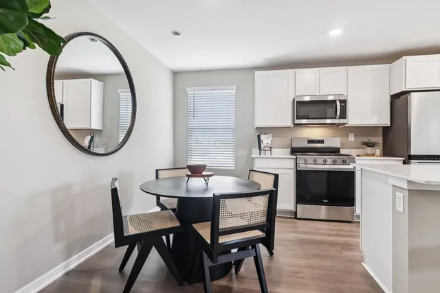 a kitchen with a dining table chairs and a refrigerator