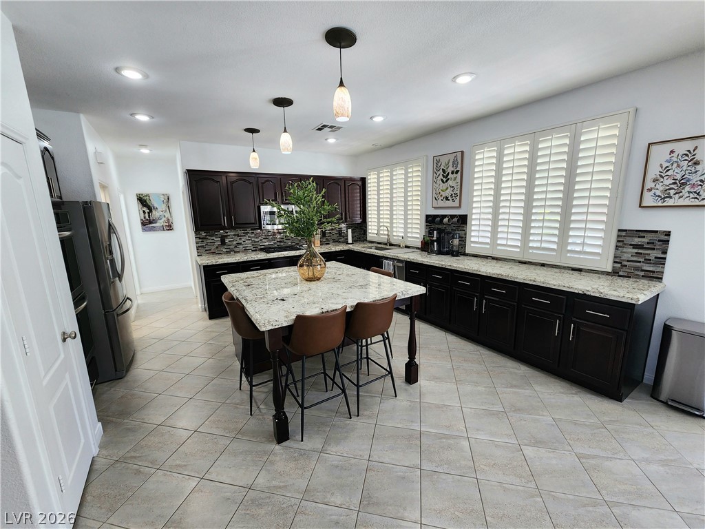 2743 Peekskill Avenue Henderson, NV 89052 - Photo 10 of 51 This kitchen showcases a central island and modern appliances, creating an inviting space for culinary endeavors.