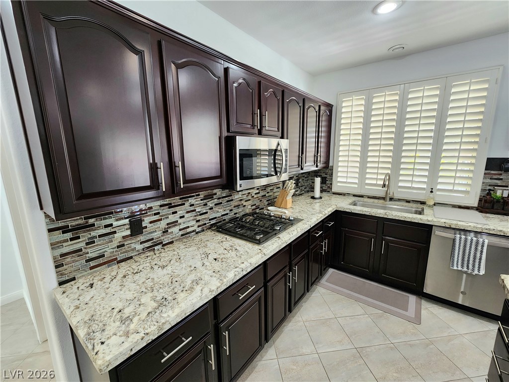 2743 Peekskill Avenue Henderson, NV 89052 - Photo 13 of 51 This modern kitchen features rich cabinetry, a stylish backsplash, and ample counter space for culinary creations.