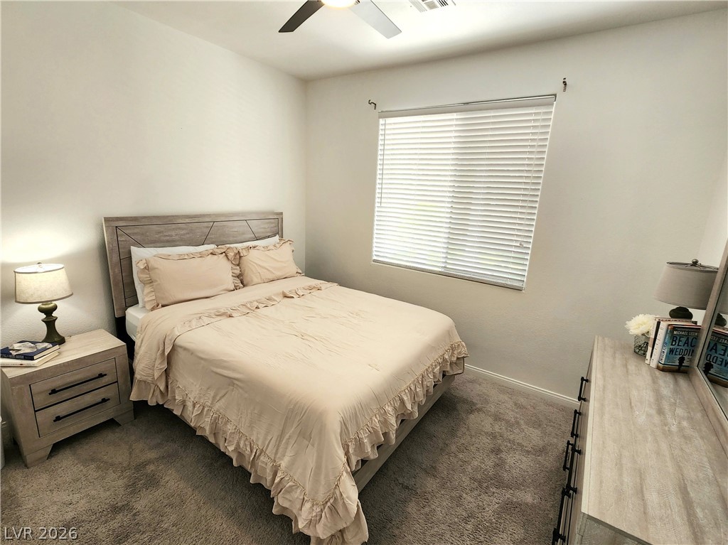 2743 Peekskill Avenue Henderson, NV 89052 - Photo 14 of 51 This cozy downstairs bedroom provides a comfortable retreat with soft lighting and ample space for relaxation.