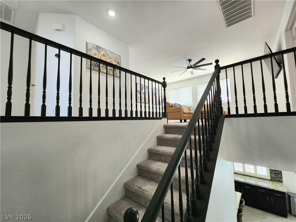 2743 Peekskill Avenue Henderson, NV 89052 - Photo 18 of 51 This interior staircase features carpeted steps and a dark wood banister.