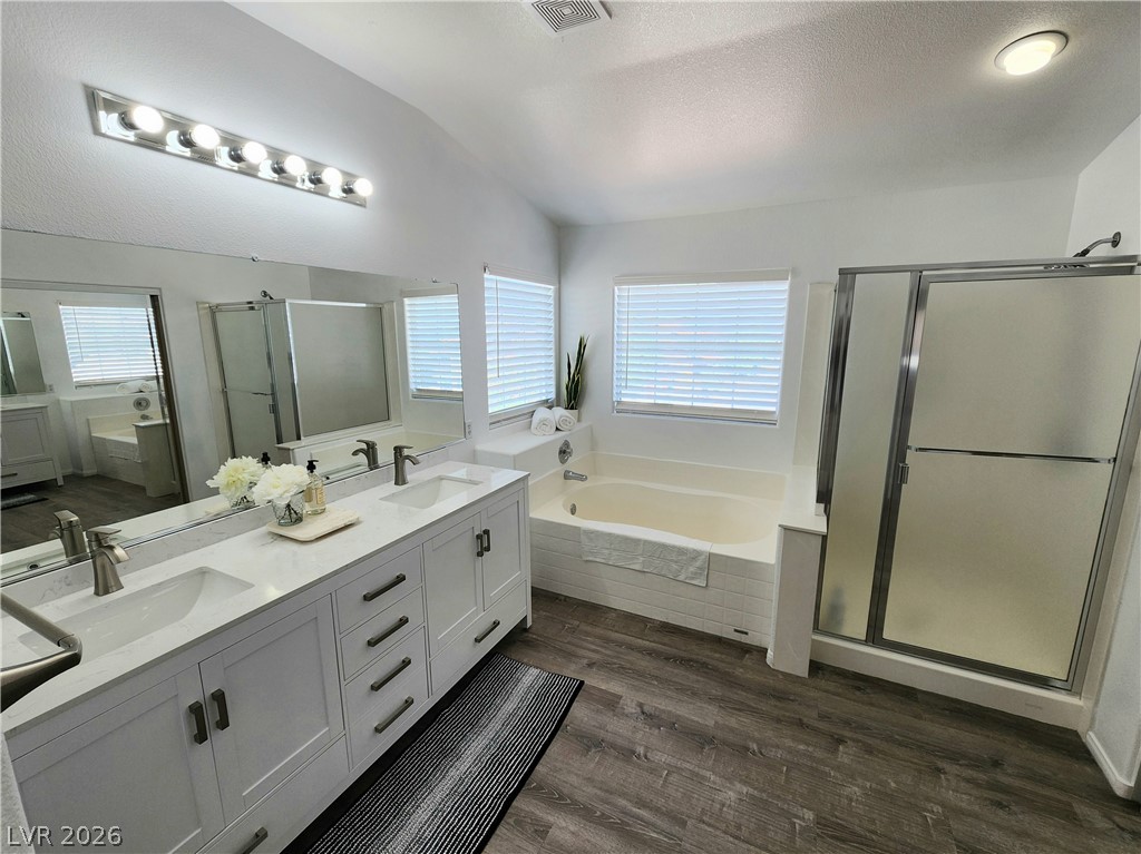 2743 Peekskill Avenue Henderson, NV 89052 - Photo 25 of 51 This spacious primary bathroom offers dual vanities, a separate soaking tub, and a glass-enclosed shower.