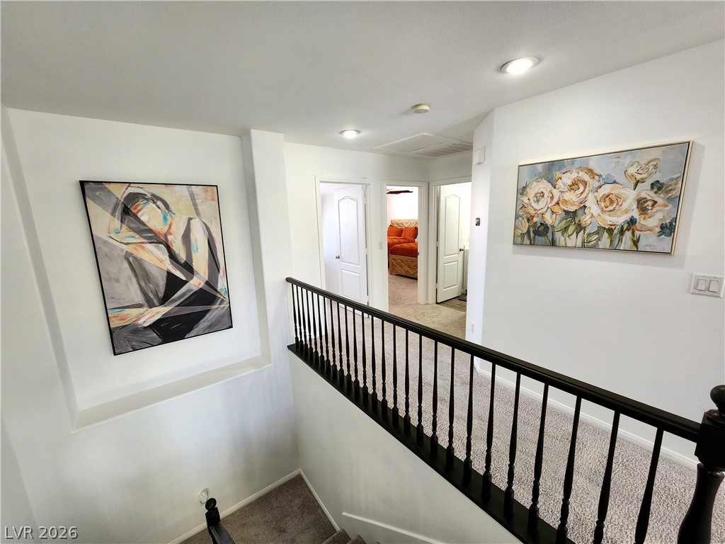 2743 Peekskill Avenue Henderson, NV 89052 - Photo 30 of 51 This interior hallway features carpeted flooring, leading to several rooms with bright white doors and recessed lighting.