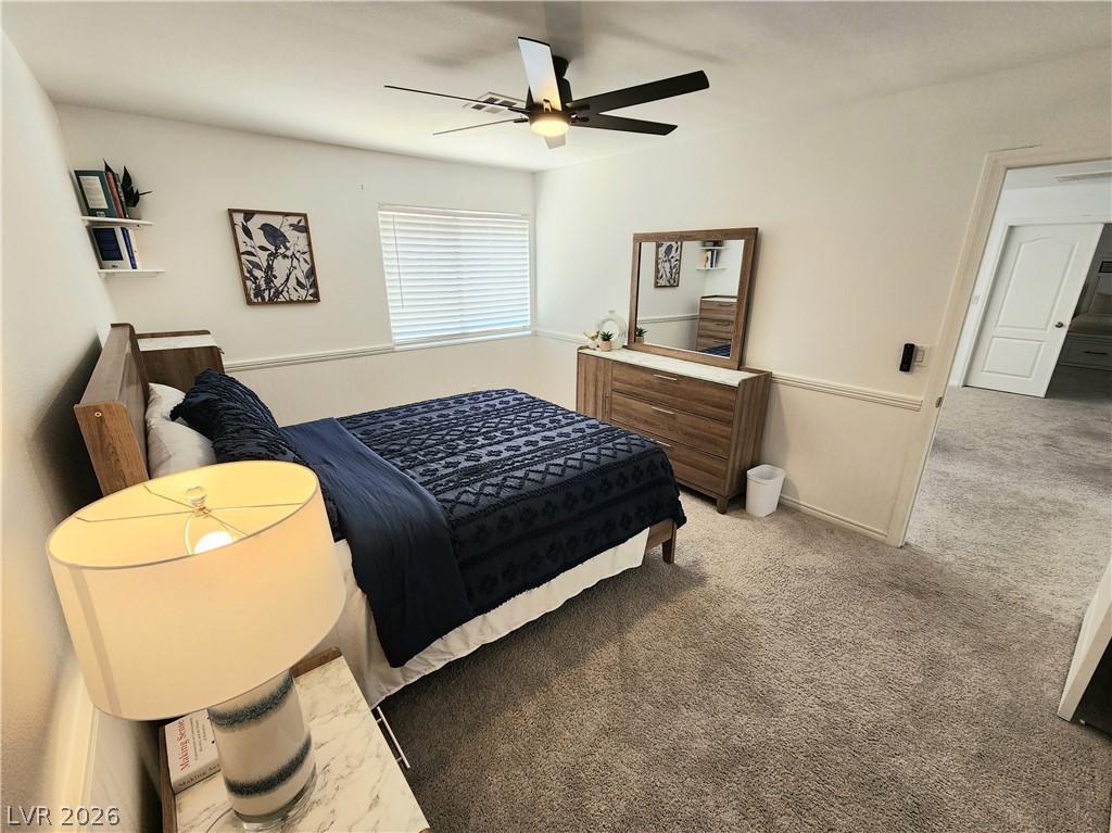 2743 Peekskill Avenue Henderson, NV 89052 - Photo 32 of 51 This cozy bedroom features plush carpeting and a modern ceiling fan, creating a comfortable and inviting atmosphere.
