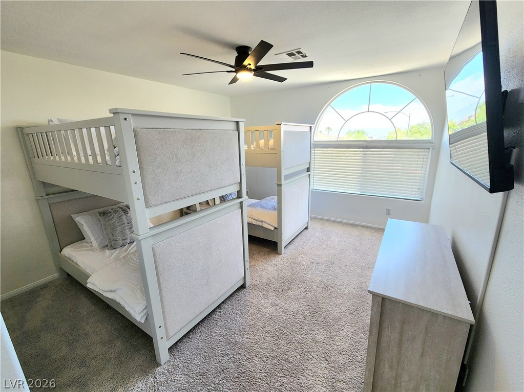 2743 Peekskill Avenue Henderson, NV 89052 - Photo 34 of 51 This spacious bedroom features ample natural light and comfortable carpeting, perfect for relaxation.