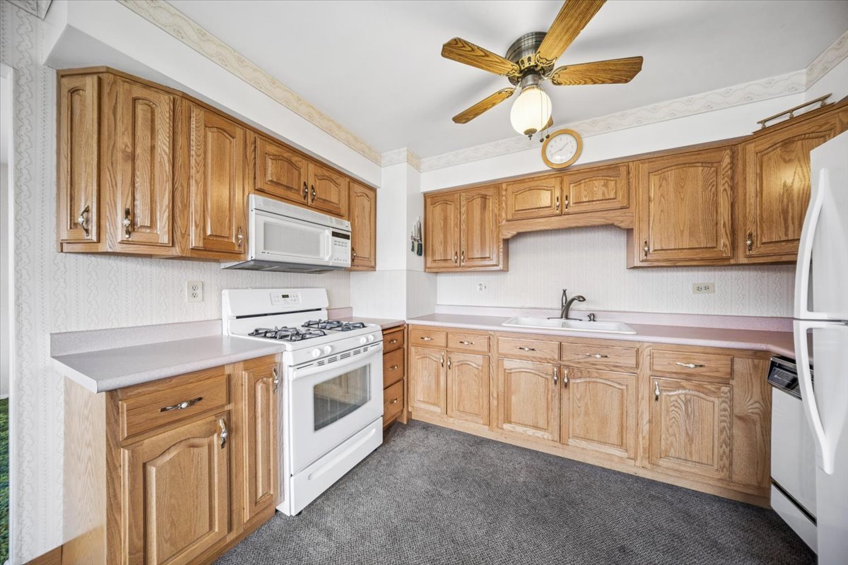 2316 185th Place Lansing, IL 60438 - Photo 9 of 21 a kitchen with white cabinets and white appliances