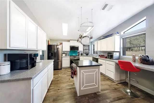a large kitchen with cabinets appliances and a center island