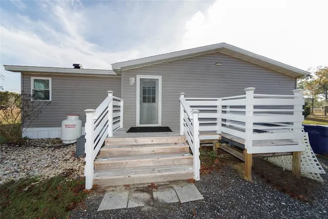 a view of a house with backyard and tree