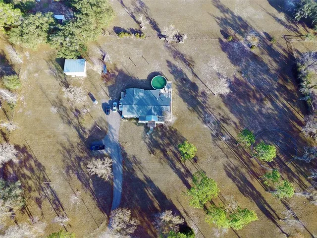 view of a lot of flowers and tree in front of house