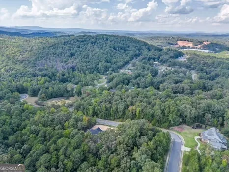 an aerial view of a houses with yard and mountain view