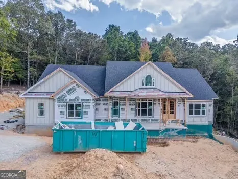 a view of a house with a yard and large tree
