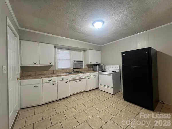 a kitchen with a refrigerator and white cabinets