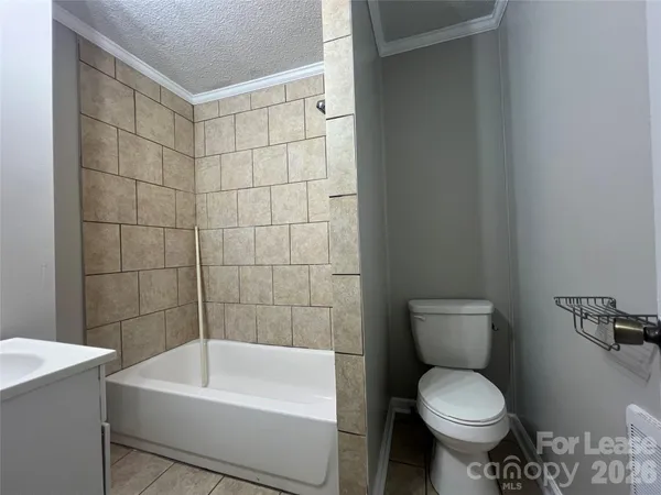 a white toilet sitting next to a white bath tub