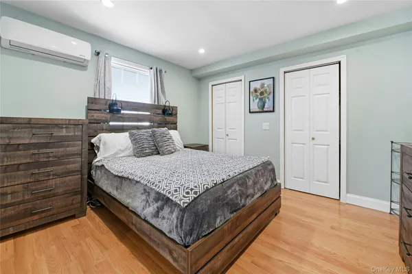 a bedroom with a bed and painting on the wall