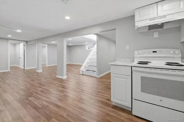a kitchen with a sink a refrigerator and white cabinets