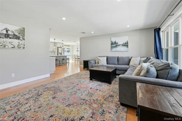 a kitchen with stainless steel appliances granite countertop a table chairs stove and wooden floor