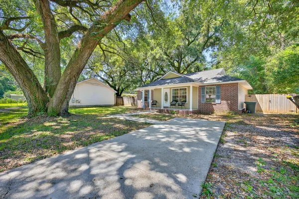a view of a house with backyard and sitting area