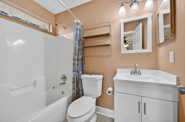 a bathroom with a sink toilet vanity and shower