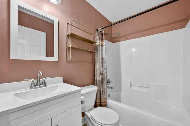 a bathroom with a sink toilet vanity and shower