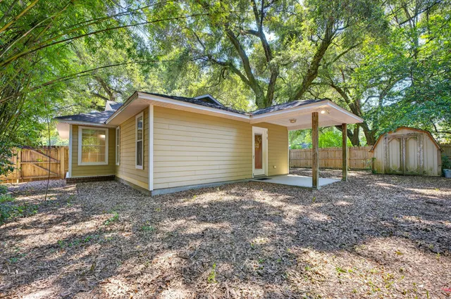 a view of a house with a yard and large tree