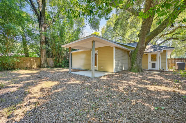a view of a house with a yard and large tree