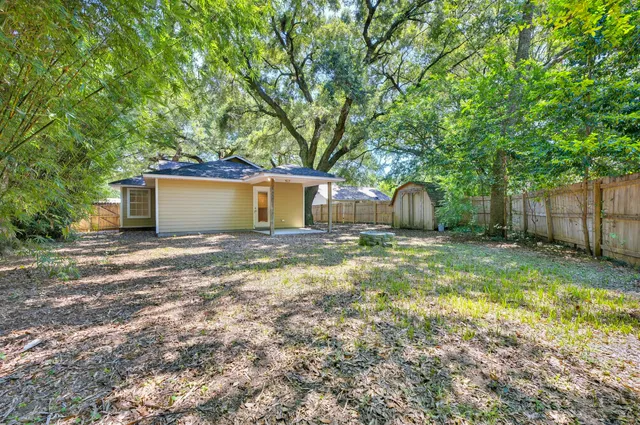 a view of a house with backyard and tree