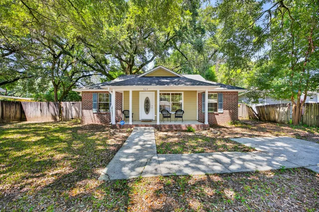 a front view of a house with yard patio and outdoor seating