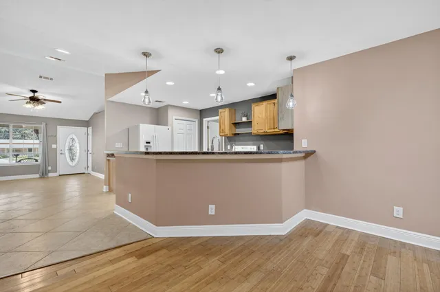 a view of kitchen with kitchen island granite countertop a stove top oven a sink and dishwasher with wooden floor