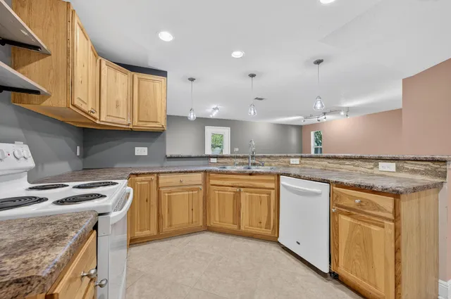 a kitchen with granite countertop a sink a counter space and cabinets