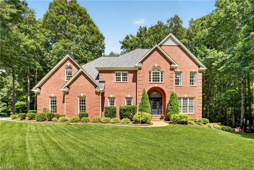 8508 Rosedale Drive Oak Ridge, NC 27310 - Photo 4 of 50 Classic brick and a lush lawn, framed by towering hardwoods.