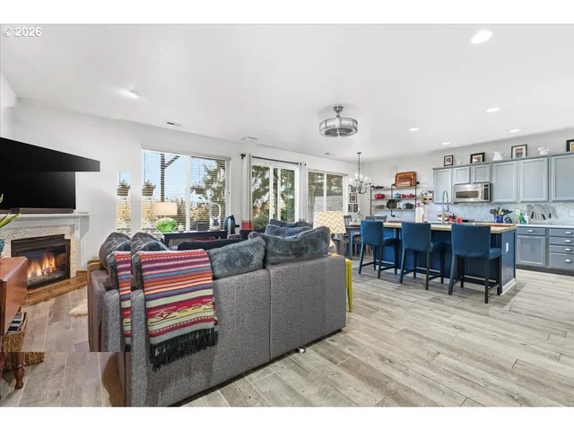 a dining hall with stainless steel appliances granite countertop a sink dishwasher and a flat screen tv