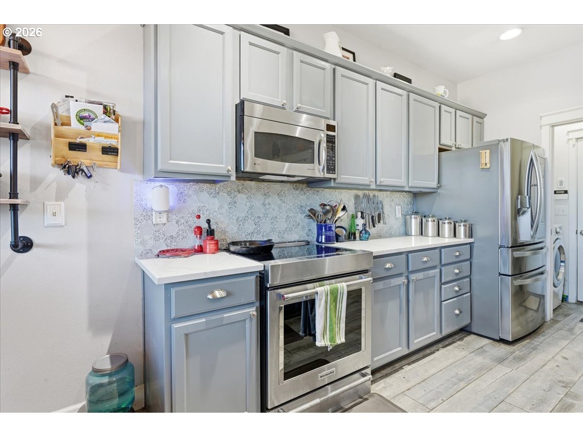 21601 Northeast Willow Glen Road Fairview, OR 97024 - Photo 6 of 48 a kitchen with stainless steel appliances granite countertop a refrigerator sink and microwave