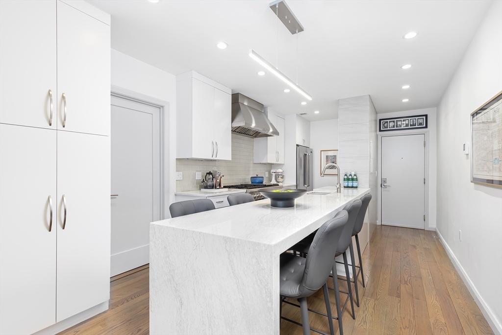76 West Rutland Square, Unit 104 Boston, MA 02118 - Photo 9 of 23 a kitchen with stainless steel appliances a white table chairs and a refrigerator