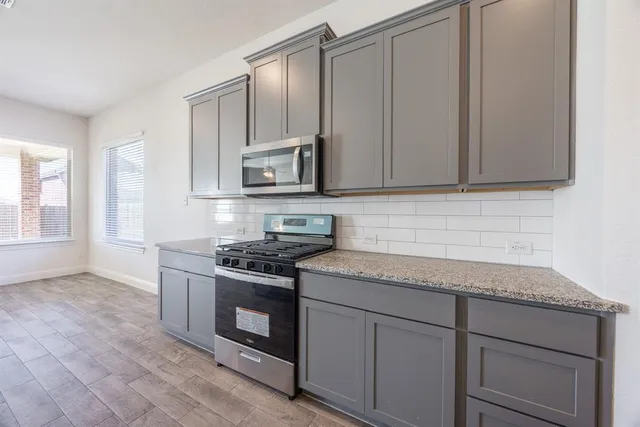 a kitchen with granite countertop cabinets stainless steel appliances and a sink
