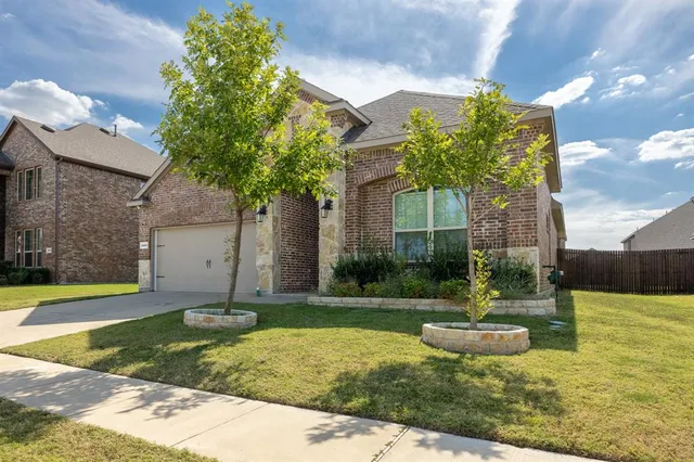 a front view of a house with a yard and trees