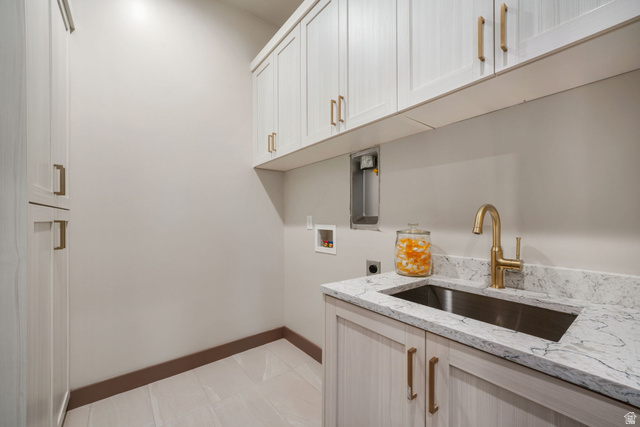 10646 North Reflection Ridge Hideout, UT 84036 - Photo 26 of 43 Utility room featuring wood-finish flooring, white cabinetry with bronze hardware, a white countertop with grey veining, a stainless steel undermount sink, and a gold-tone faucet
