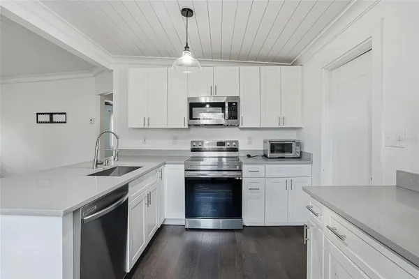 a kitchen with stainless steel appliances granite countertop a sink stove a microwave and cabinets