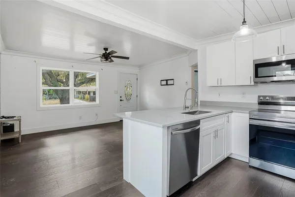 a kitchen with stainless steel appliances a stove a sink and a microwave