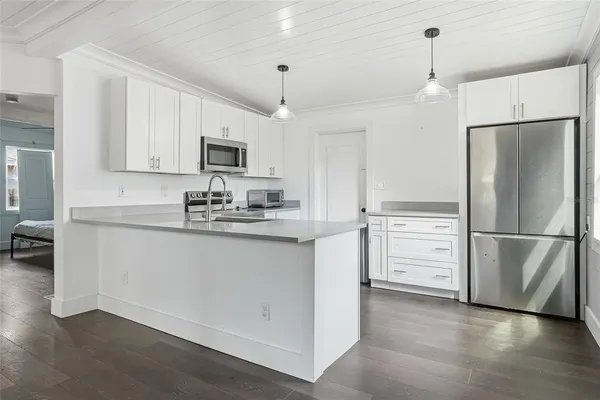 a kitchen with stainless steel appliances a refrigerator sink and microwave