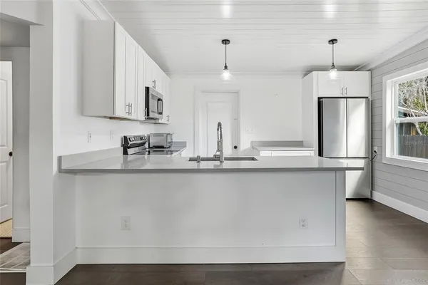 a kitchen with stainless steel appliances granite countertop a sink a stove and a wooden floors