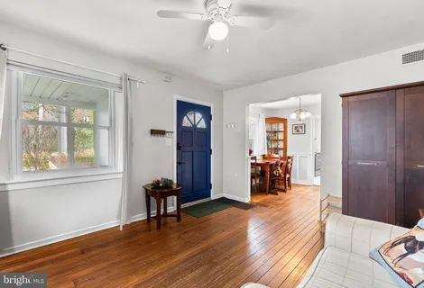 a view of a livingroom with wooden floor and furniture