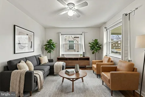 a living room with furniture a potted plant and a window